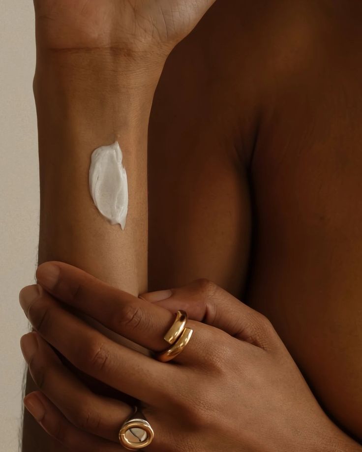 femme utilisant une noisette de crème pour le corps blanche.